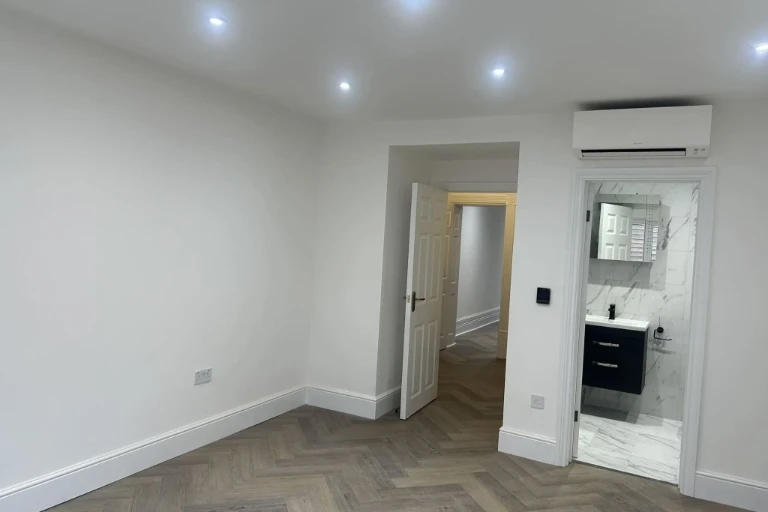 Newly renovated bathroom featuring marble-effect wall tiles and compact vanity unit