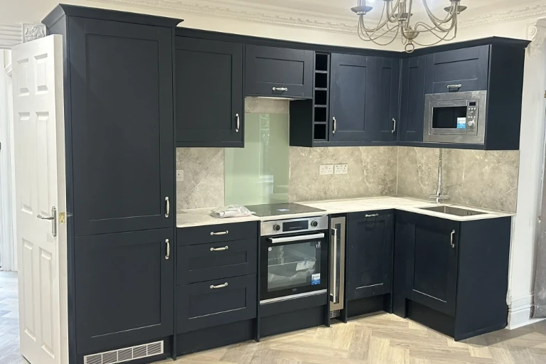 Modern kitchen renovation with dark fitted cabinets and integrated appliances