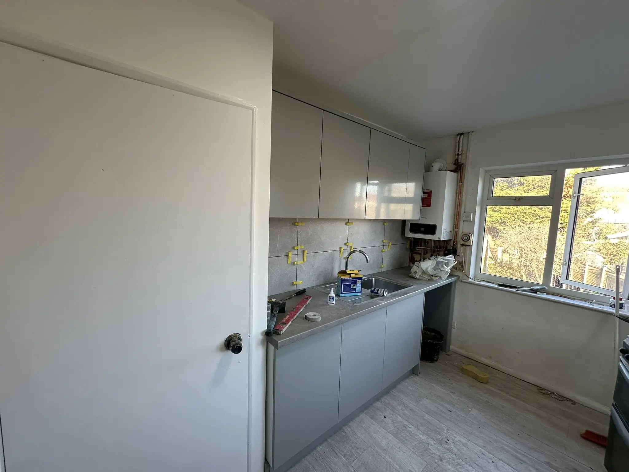 Grey kitchen cabinet units being fitted in a semi-detached property, Sidcup Bexley