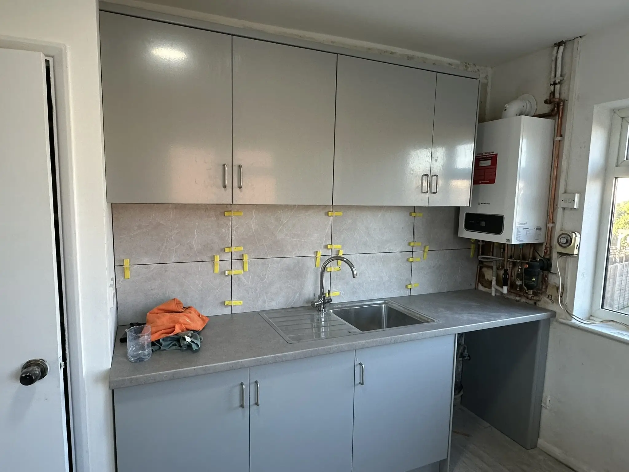 Grey composite worktop and base cabinets fitted mid-renovation, Sidcup kitchen