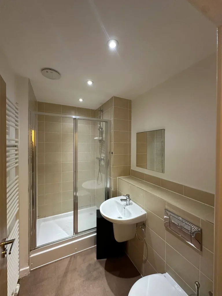 A shower room with a concealed cistern and recessed shelf, Addlestone