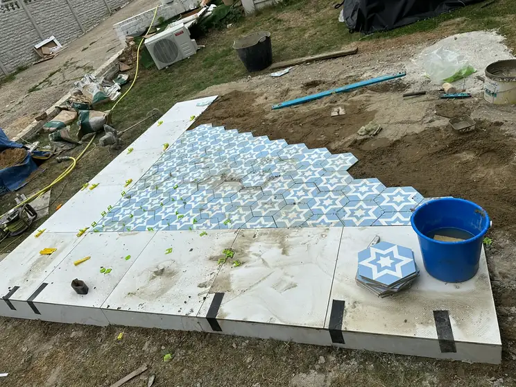 Patterned hexagonal tiles being set out in the middle of a new porcelain patio in Hazlemere