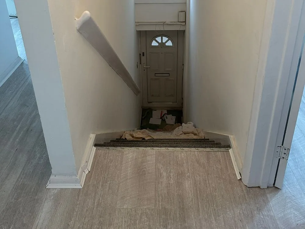 Renovated landing and staircase leading down to the front door, with white walls and grey plank flooring, Sidcup
