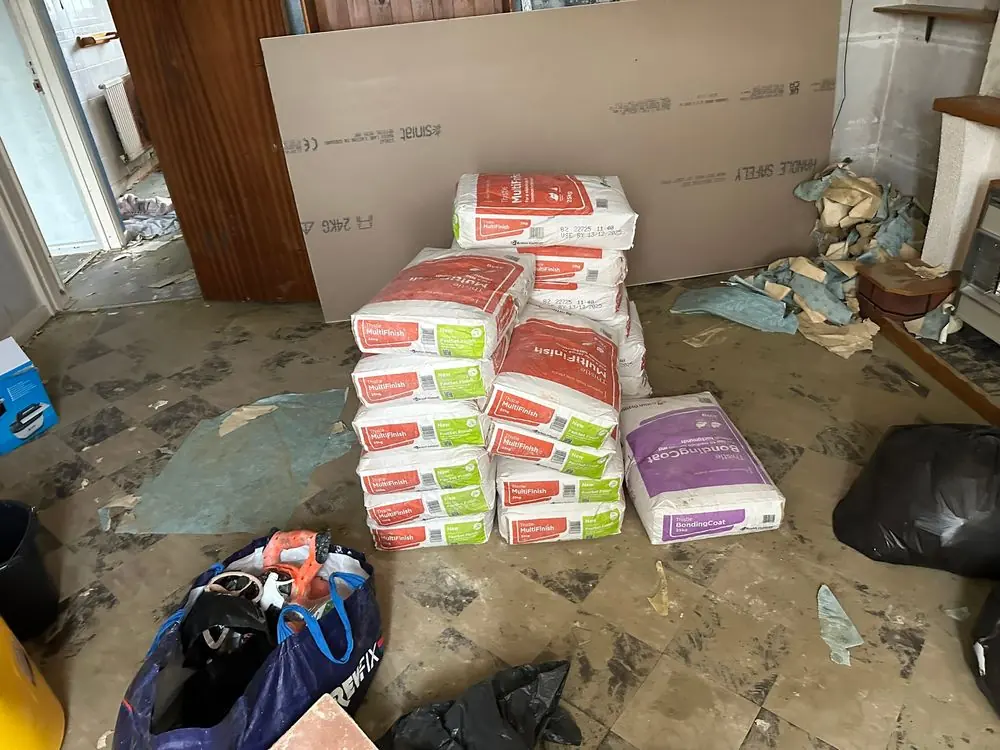 Thistle MultiFinish and BondingCoat plaster bags with Siniat plasterboard sheets on site during a Sidcup home renovation