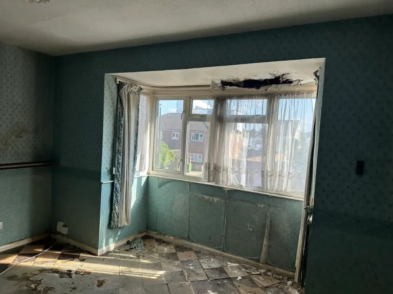 The ceiling above the bay window had come down, with peeling paper and broken floor tiles below, Blendon, Sidcup