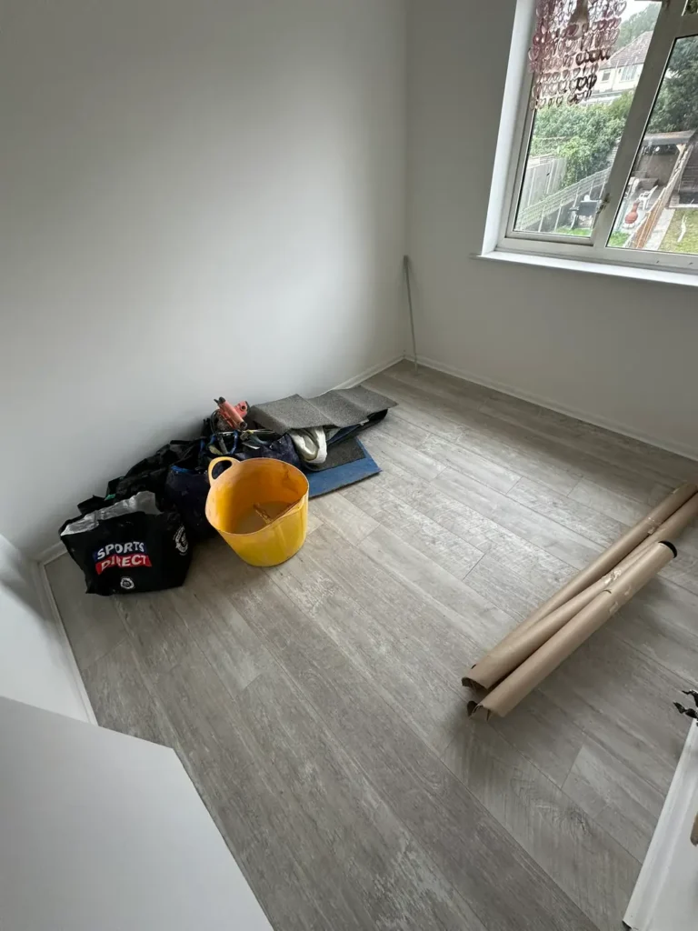 October 2025: grey oak-effect plank flooring going down in a bedroom, Blendon, Sidcup