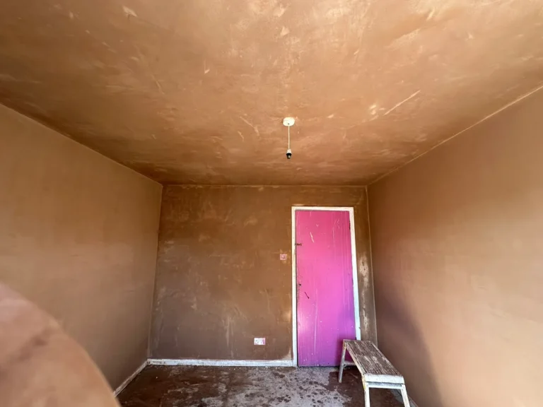 June 2025: a bedroom freshly plastered, the old pink paint still on the door, Wexham Court, Slough