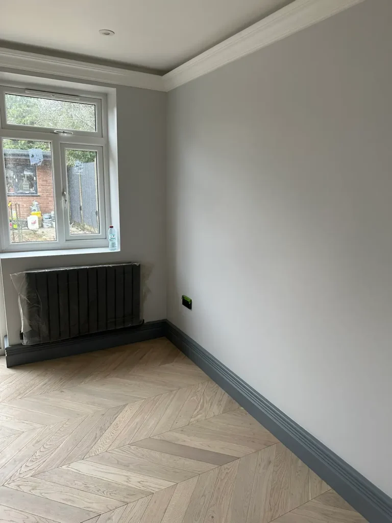 A finished room with chevron flooring and a column radiator, Stanborough, Watford