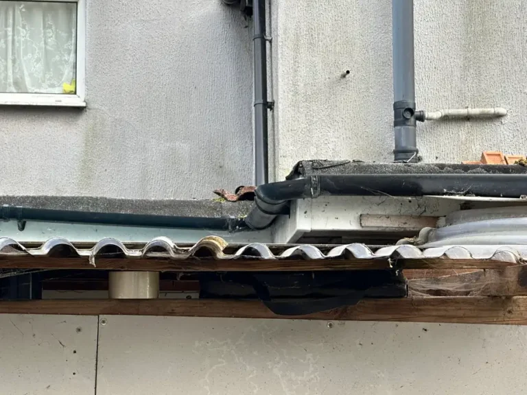 Rotten fascia and a broken corrugated section along the edge, Wealdstone