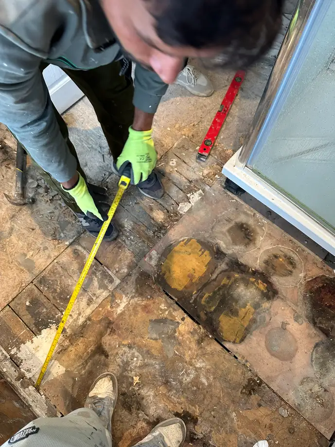 September 2025: the bathroom floor taken up, showing water-damaged boards, Wembley Hill, Wembley