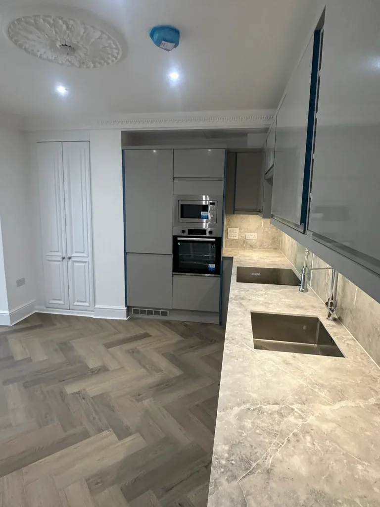 A kitchen with stone-effect worktops and integrated appliances, Walpole, West Ealing