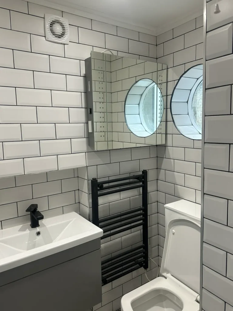 White metro tiles, a black towel rail and a wall-hung basin, Walpole, West Ealing