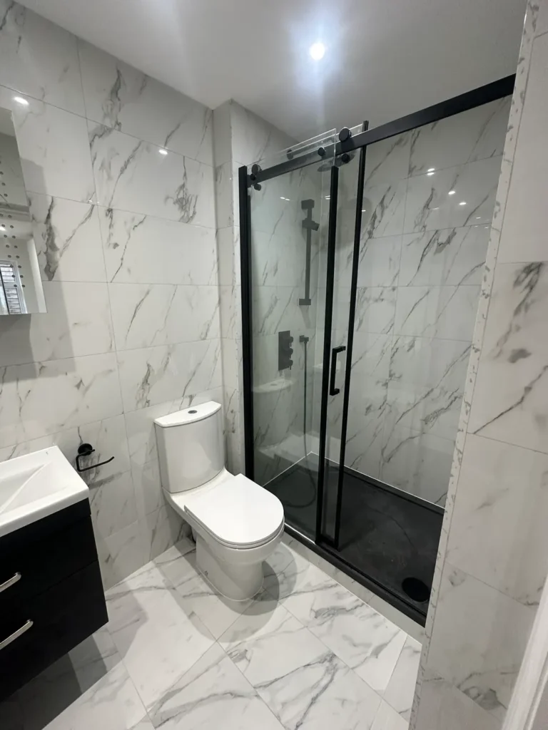 A marble-effect shower room with a black-framed sliding screen, Walpole, West Ealing
