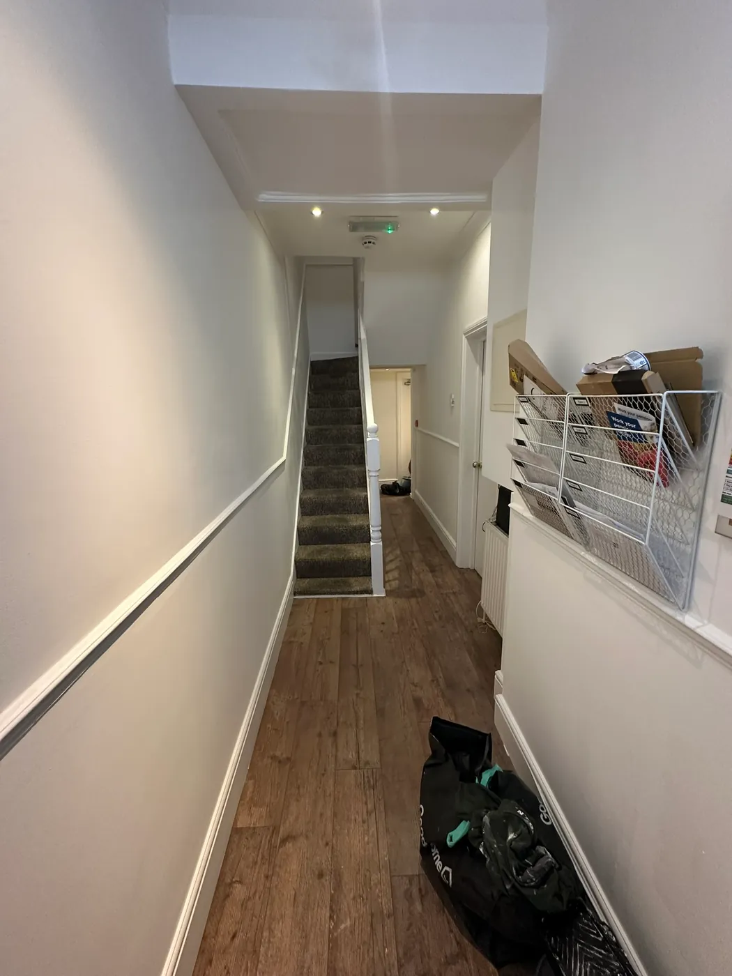 Ground-floor hallway of a Woolwich house repainted up to the foot of the stairs