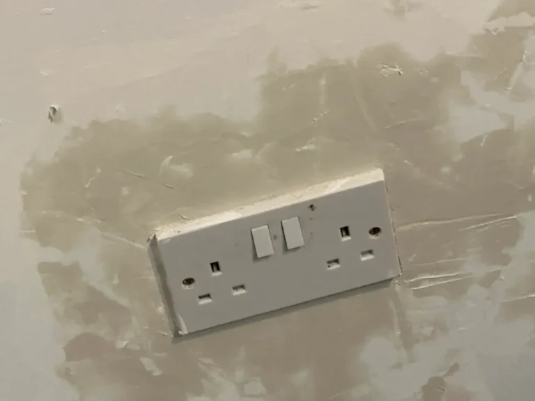 December 2024: damaged plaster around a socket filled and patched, Woolwich Common, Woolwich